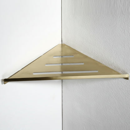Gold triangular shower shelf mounted on a white wall. Stylish golden bathroom rack. Modern bathroom rack, minimalist and timeless pieces for bathroom. 