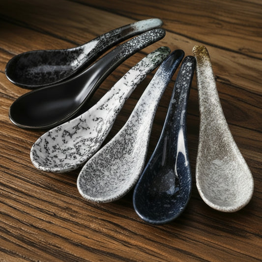 Set of six ceramic spoons with speckled finish on a wooden table. Handcrafted ceramic spoon in different colors. 