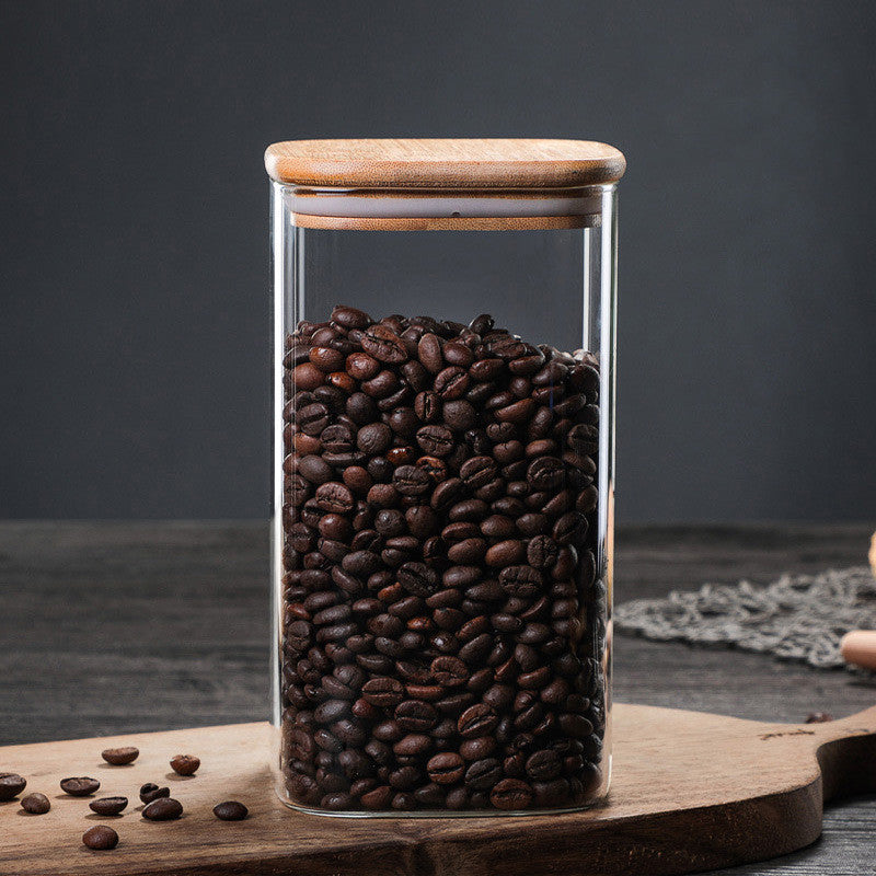 Jar with wooden lids filled with coffee beans on a wooden kitchen surface. A warm minimalist interior with simple decor and simple design. Storage kitchen jar. 