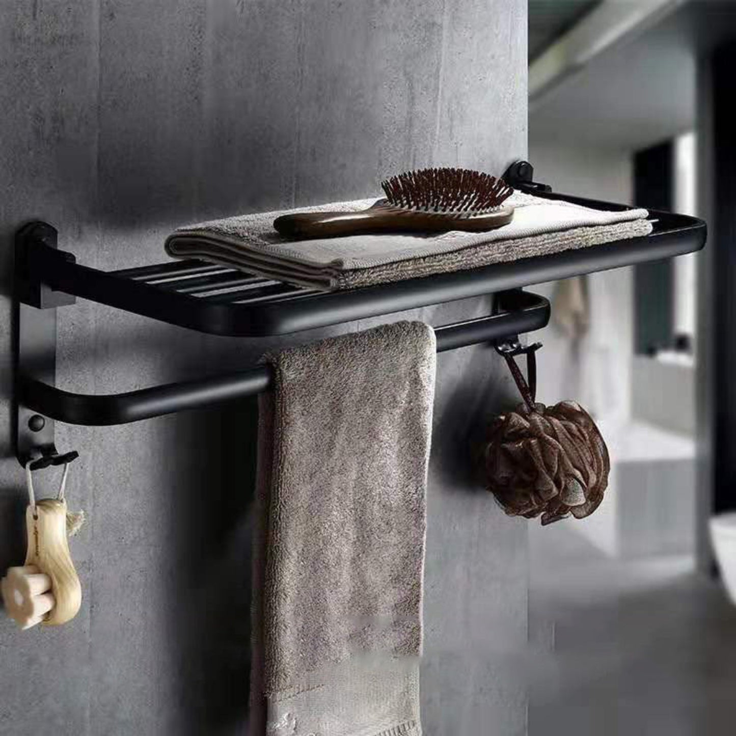 Black towel rack with towels and a brush on a gray wall. Modern black accessories, minimalist designs and timeless pieces for every bathroom. 