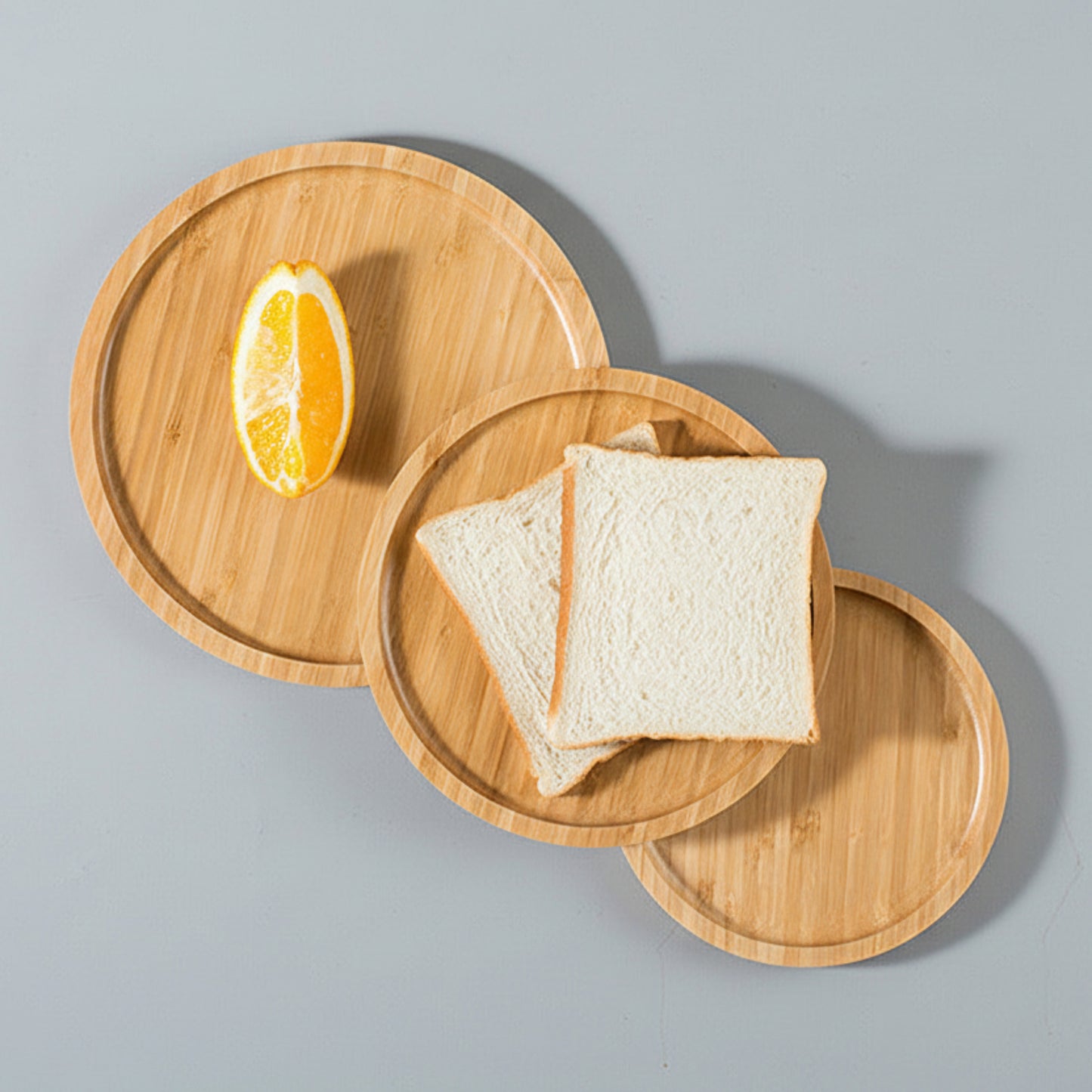 Wooden plates with toast and an orange slice on a gray background. Earthy, warm background. Natural material. 