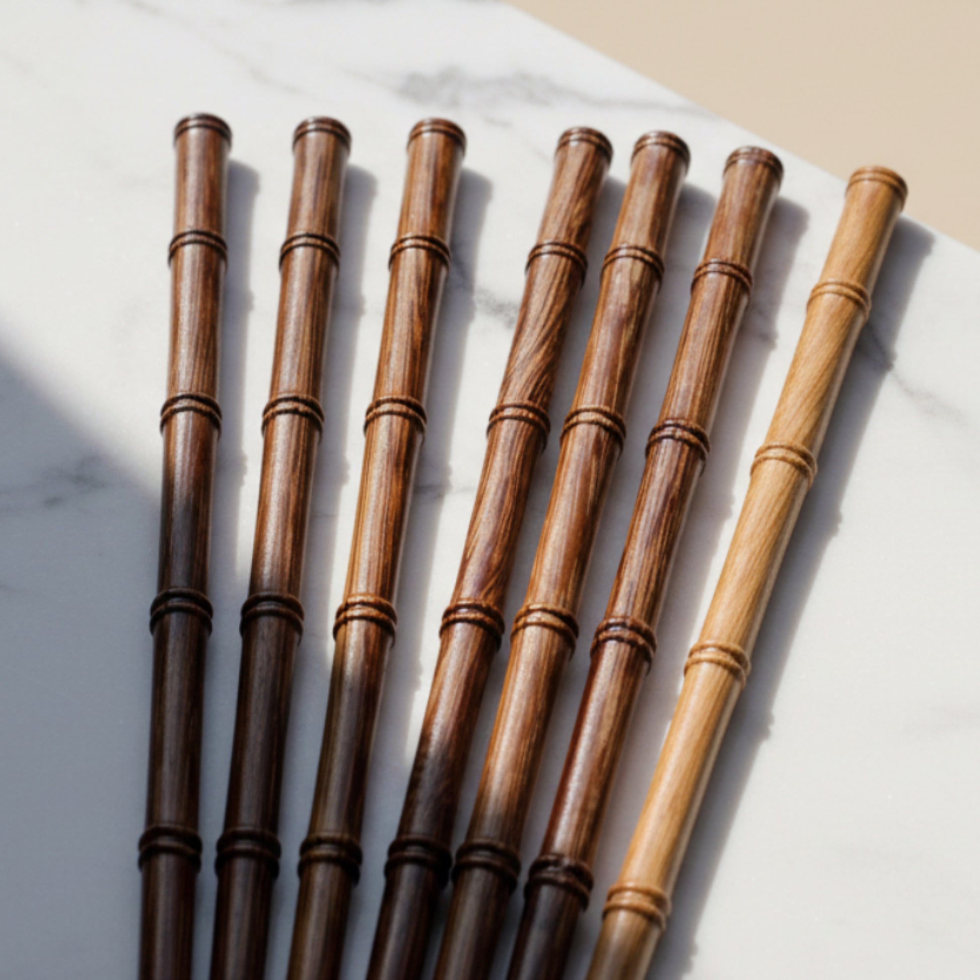Set of seven wooden chopsticks on an grey marble kitchen surface with a beige background. Natural and pure material and ambience. 