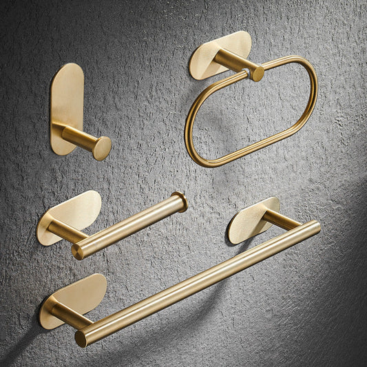 Set of gold bathroom fixtures including a hook, towel ring, and towel bar on a gray textured background. Stylish golden bathroom rack. Modern bathroom rack, minimalist and timeless pieces for bathroom. 