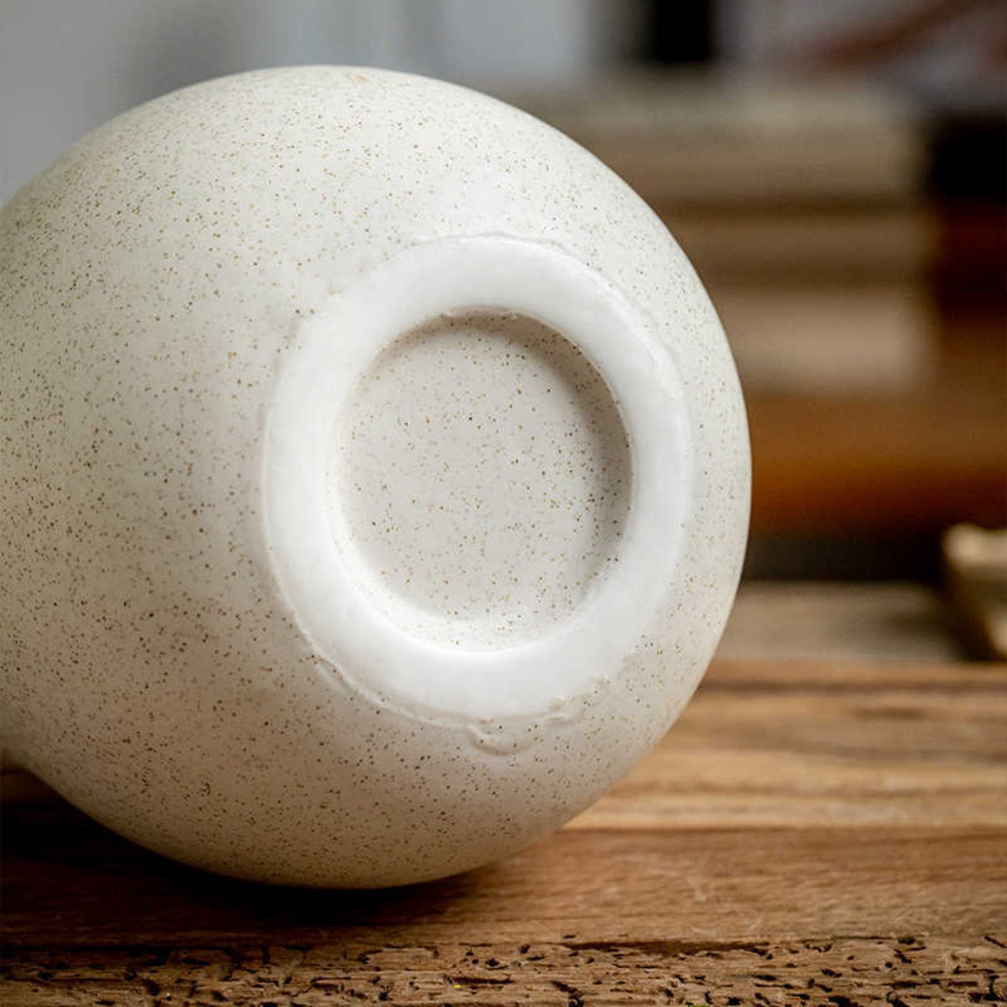 Beige Scandinavian decor inspired ceramic binaural vase bottom on a table. Warm tones. Minimalist interiors.