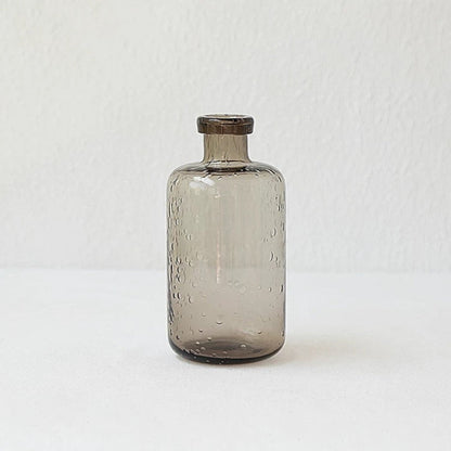 A collection of bubble glass vases in various sizes, with a geometric shape and a translucent stained glass appearance on a white surface and on a white background. 