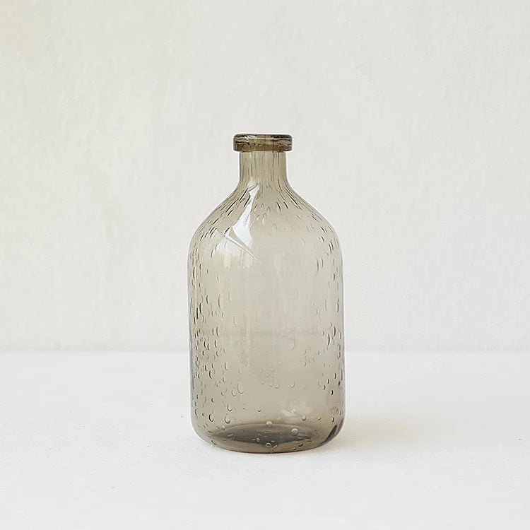 A collection of bubble glass vases in various sizes, with a geometric shape and a translucent stained glass appearance on a white surface and on a white background.