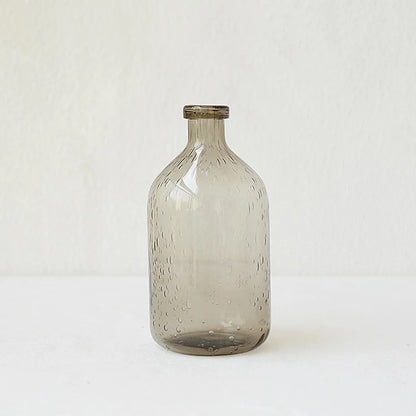 A collection of bubble glass vases in various sizes, with a geometric shape and a translucent stained glass appearance on a white surface and on a white background.