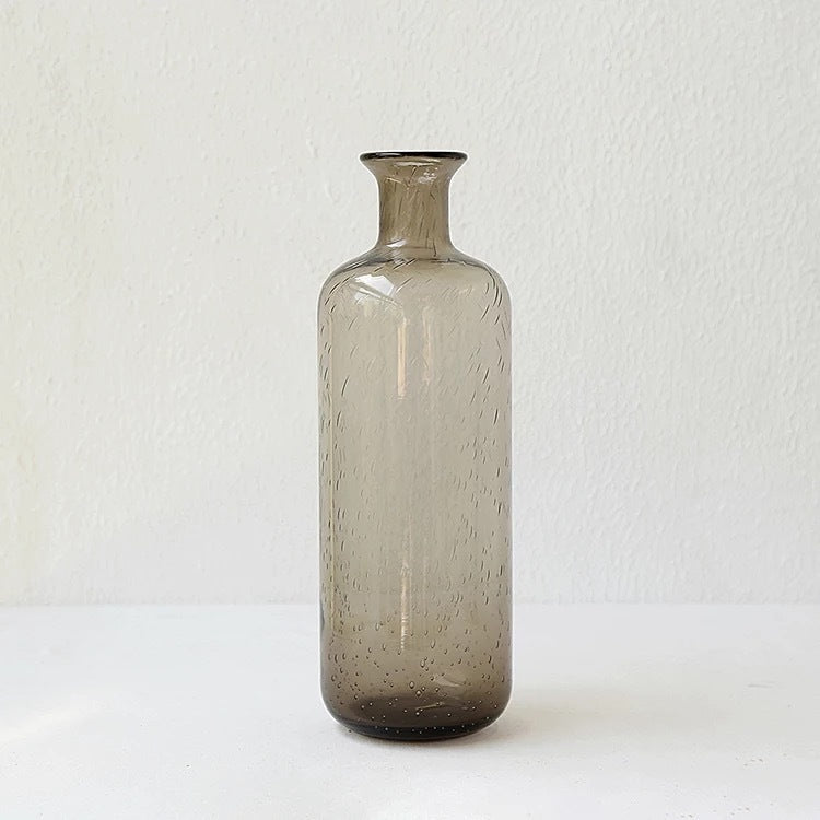 A collection of bubble glass vases in various sizes, with a geometric shape and a translucent stained glass appearance on a white surface and on a white background. 