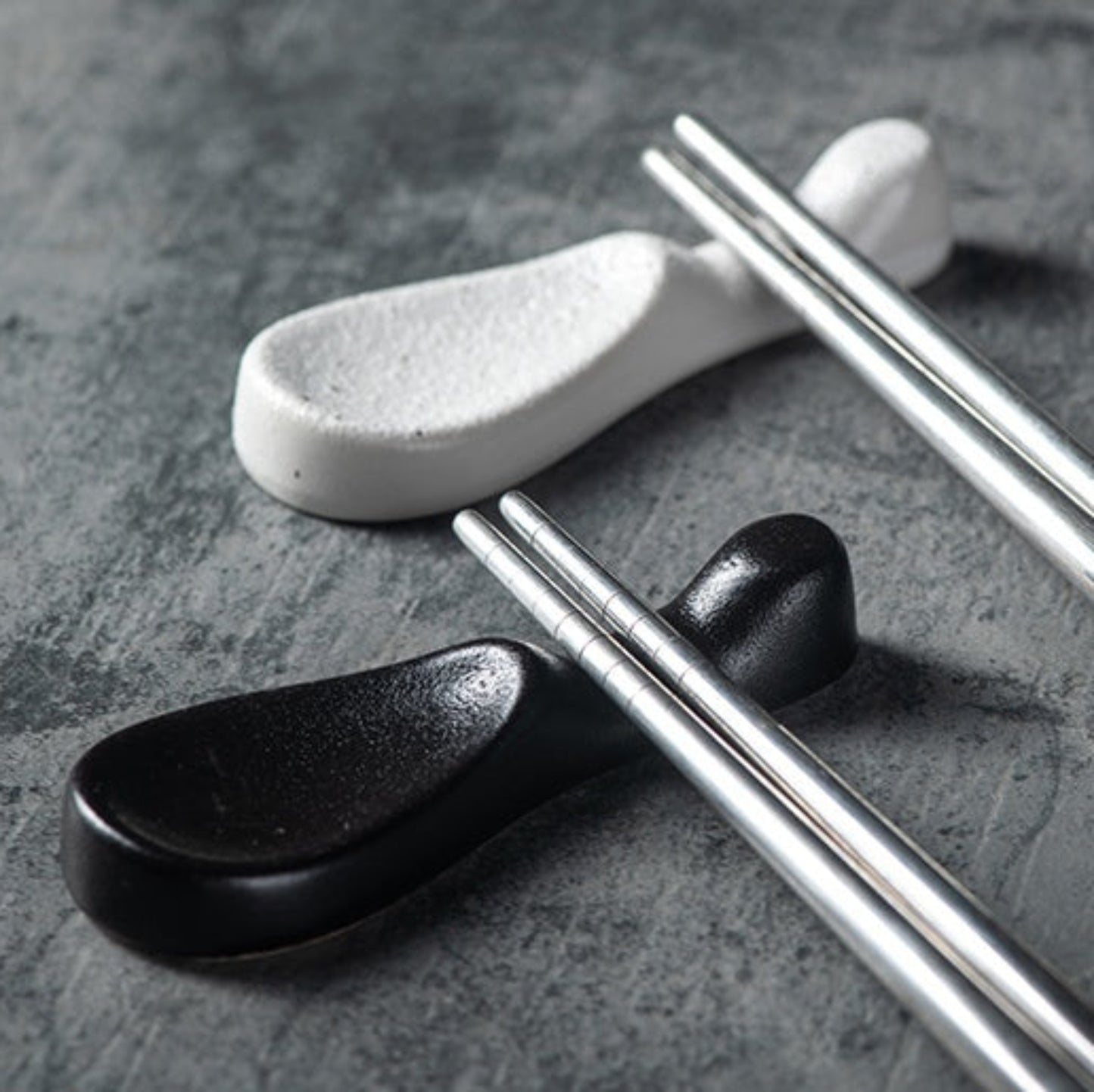 Stylish black and white ceramic chopsticks holder japanese style. modern kitchen accessories on a dark table. 