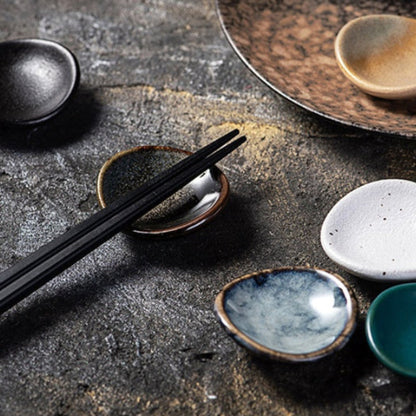 Stylish ceramic chopsticks holder with chopsticks on it, Japanese style on a dark stony surface. modern kitchen accessories, timeless pieces. 