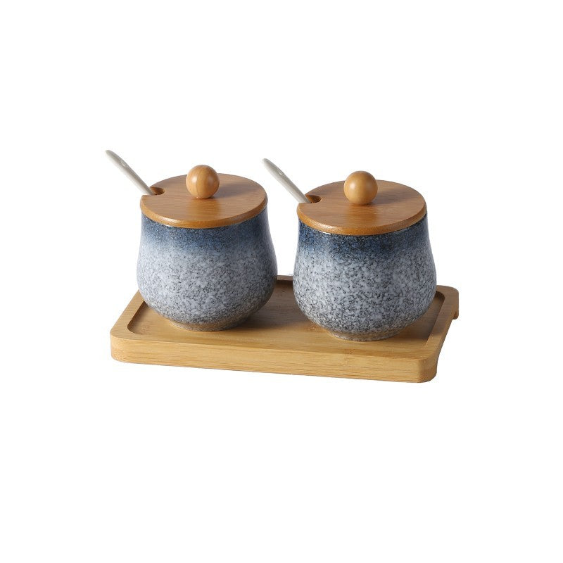 A set of two ceramic jars with Japanese style designs, featuring a speckled blue and white pattern on a white background. The jars come with wooden lids and are displayed on a wooden tray.
