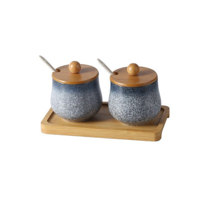 A set of two ceramic jars with Japanese style designs, featuring a speckled blue and white pattern on a white background. The jars come with wooden lids and are displayed on a wooden tray.