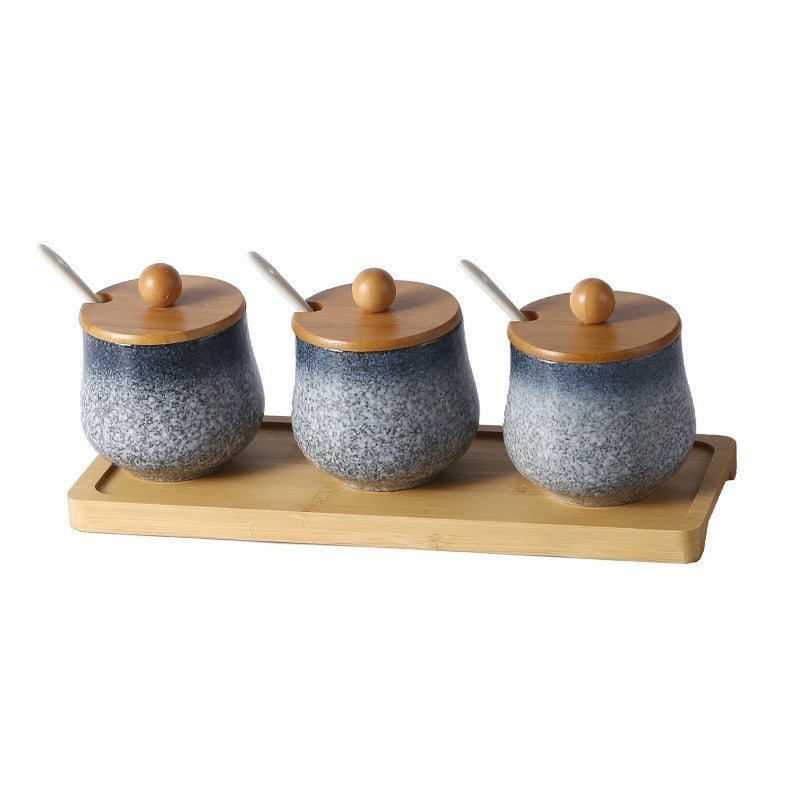 A set of three ceramic jars with Japanese style designs, featuring a speckled blue and white pattern on a white background. The jars come with wooden lids and are displayed on a wooden tray.