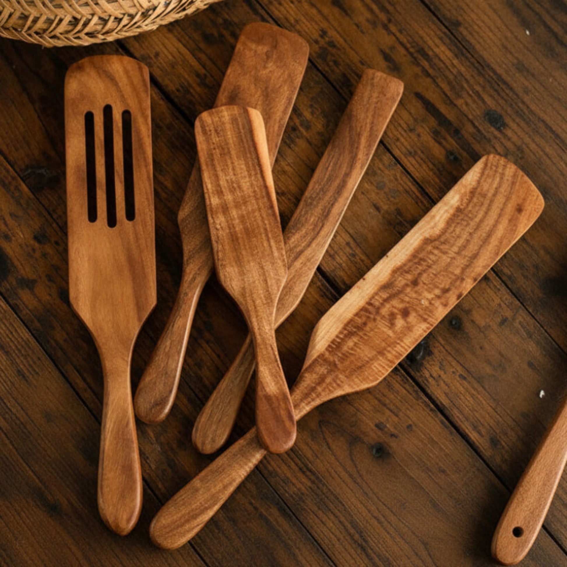 Set of five wooden kitchen utensils on a wooden surface. Natural and earthy kitchen cooking spatula. 