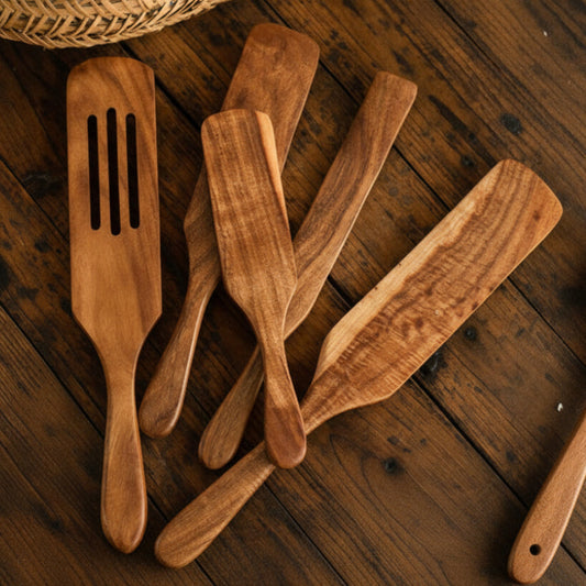 Set of five wooden kitchen utensils on a wooden surface. Natural and earthy kitchen cooking spatula. 
