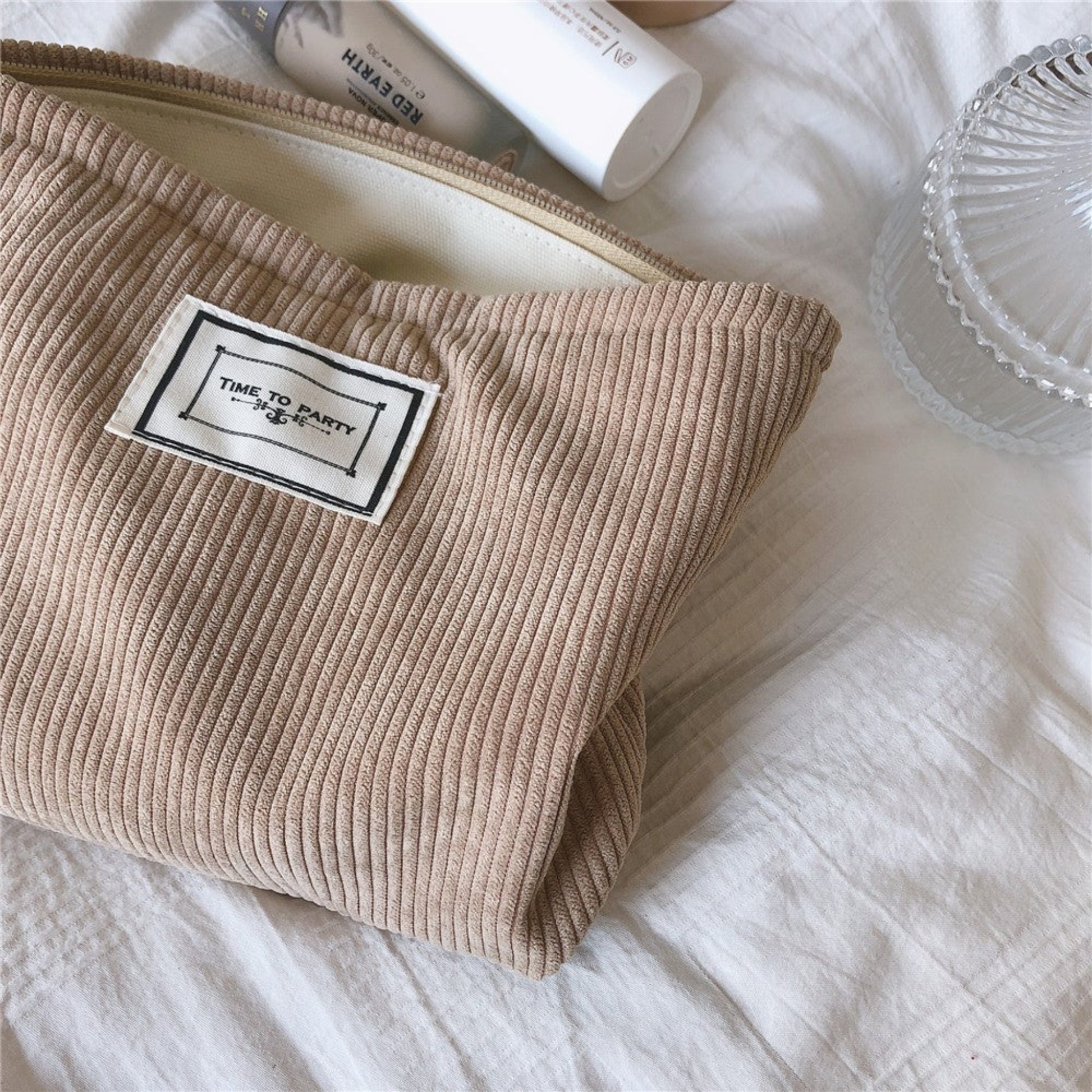 Beige corduroy cotton pouches on a neutral white background. Minimalist accessories inspired by natural materials and Scandinavian design. 