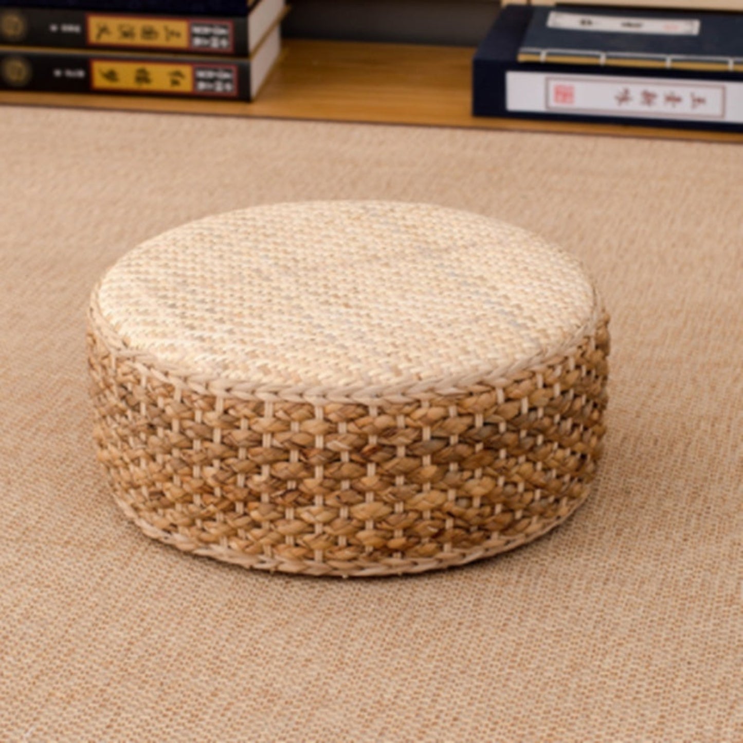 Woven ottoman on a beige carpet with books in the background. 
Earthy home decor inspired by natural textures and warm tones. Perfect for creating a calm, cozy interior with timeless minimalist design.