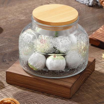 Glass jar with bamboo lid containing decorative items on a wooden surface. earthy and modern look and feel. Kitchen decor. 