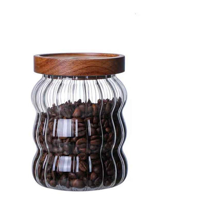One medium glass jar with wooden lid, filled with coffee beans and on a white background. Scandinavian kitchen decor inspired. Simplicity, natural materials, earthy, warm, pure. 