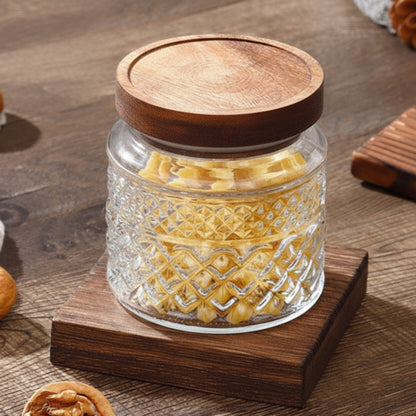 Glass jar with wooden lid on a wooden surface. Jar with earthy and warm tones. 