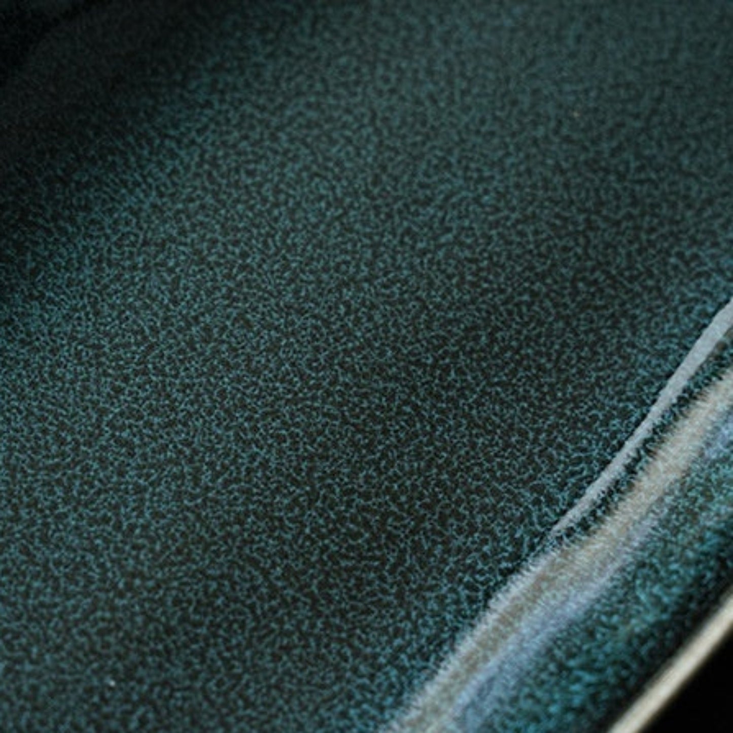 Close-up of a high-quality green ceramic plate with a visible seam.