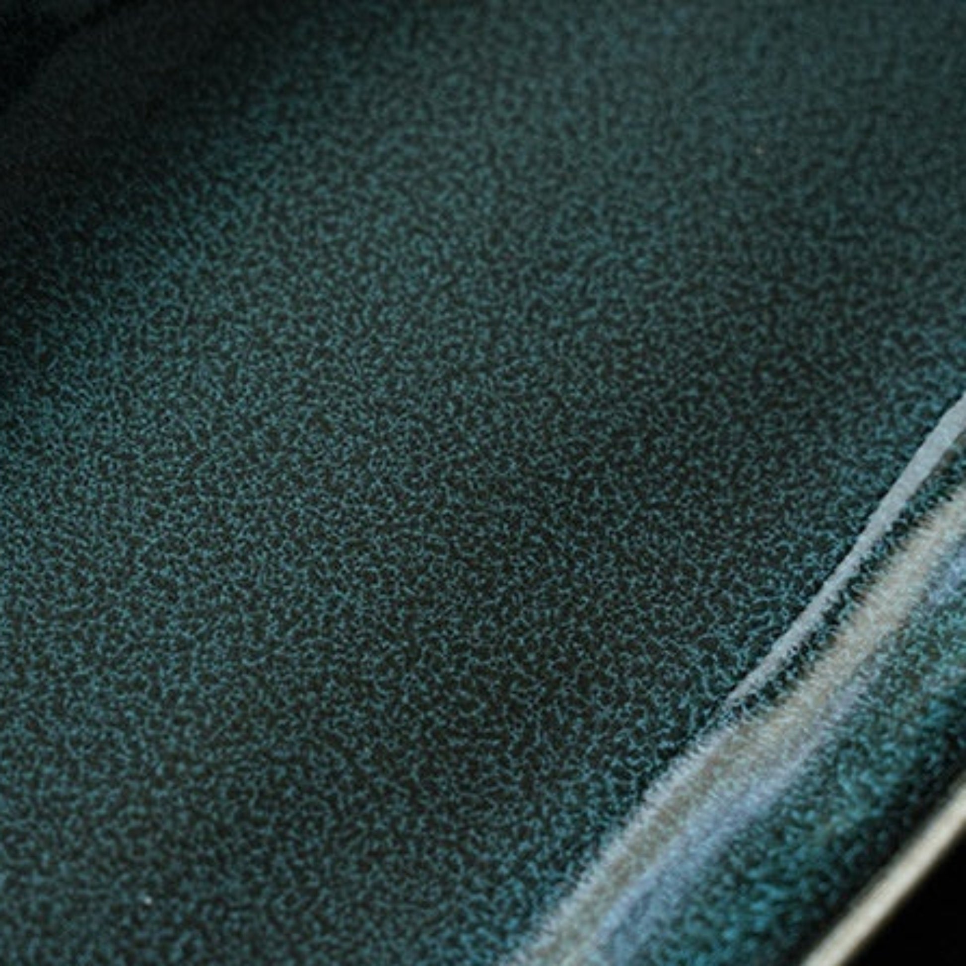 Close-up of a high-quality green ceramic plate with a visible seam.