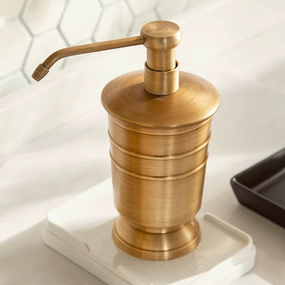 A of gold-colored copper bathroom accessories - soap dispenser on a white surface. Stylish and timeless golden bathroom decor for bathroom or kitchen.
