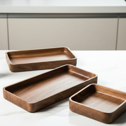 Three wooden trays of different sizes on a bright grey marble kitchen surface with a neutral kitchen background. Wooden platter. Hand-painted and eco-friendly. Japanese minimalist and natural style.