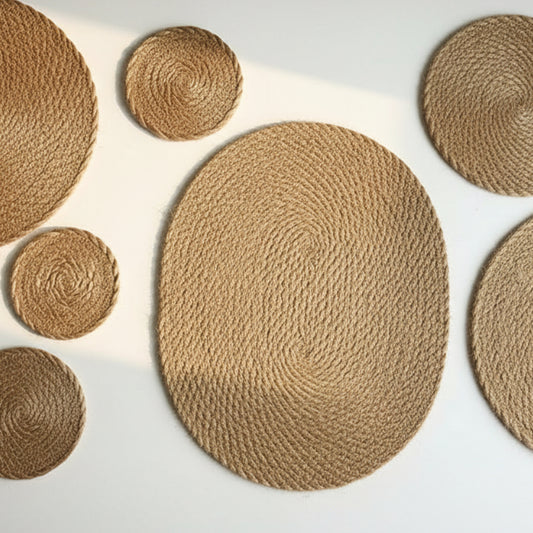 Set of jute heat proof mat in different sizes on a white surface. Warm and earthy decor pieces. 