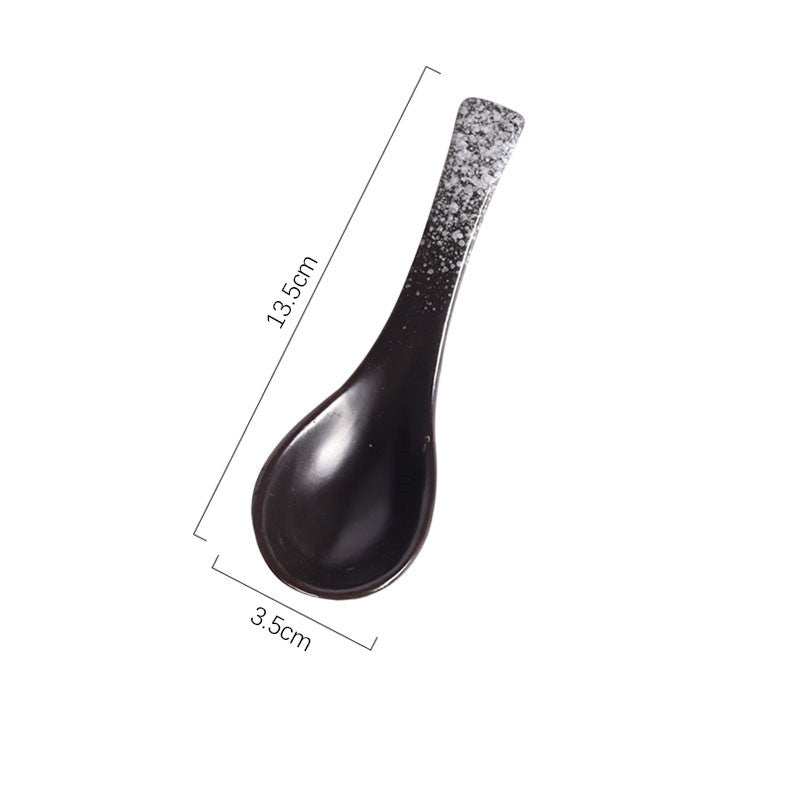 A handcrafted ceramic spoons with a speckled pattern in shades of black, grey and white on a white background and measurements. Handcrafted ceramic spoon in different colors. 