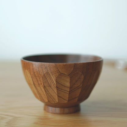 Wooden bowl on a wooden surface with a blurred background. Natural and earthy decor styling. 
