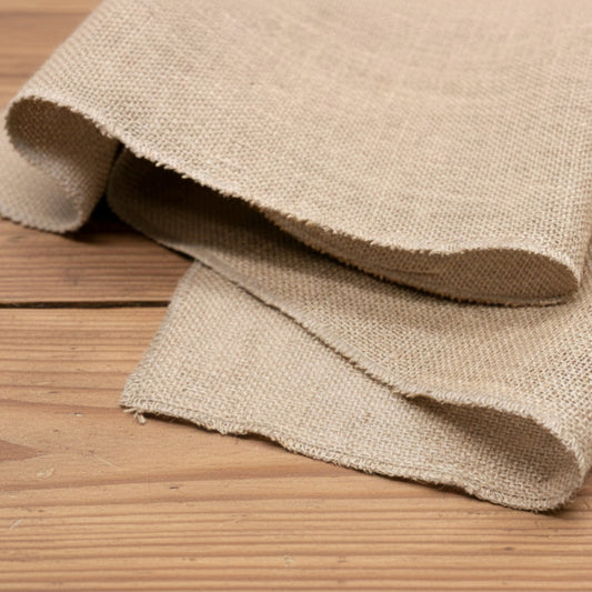 Jute table runner on a wooden table. Natural decor styling for calm and earthy design. Harmony for every table and room. 