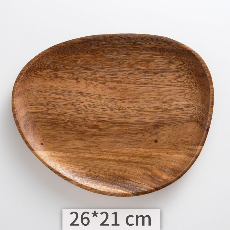 A set of acacia wooden trays with an irregular shape, displayed in various sizes on a white kitchen surface. Natural decor. Minimalist decor piece with warmth and harmony. 