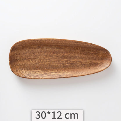 A set of acacia wooden trays with an irregular shape, displayed in various sizes on a white kitchen surface. Natural decor. Minimalist decor piece with warmth and harmony. 