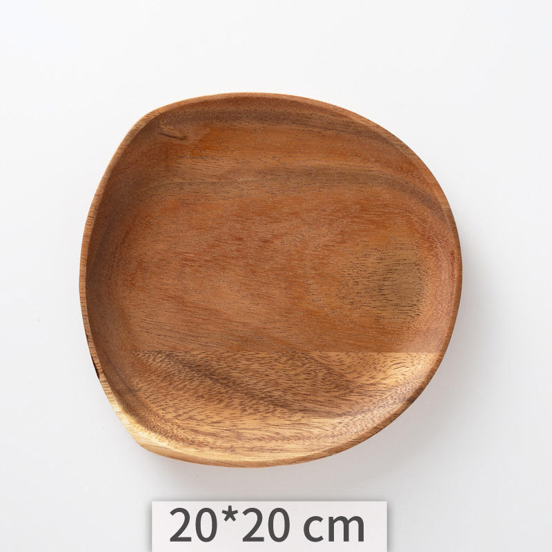 A set of acacia wooden trays with an irregular shape, displayed in various sizes on a white kitchen surface. Natural decor. Minimalist decor piece with warmth and harmony. 
