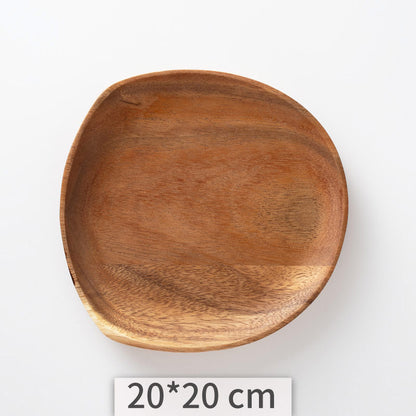 A set of acacia wooden trays with an irregular shape, displayed in various sizes on a white kitchen surface. Natural decor. Minimalist decor piece with warmth and harmony. 
