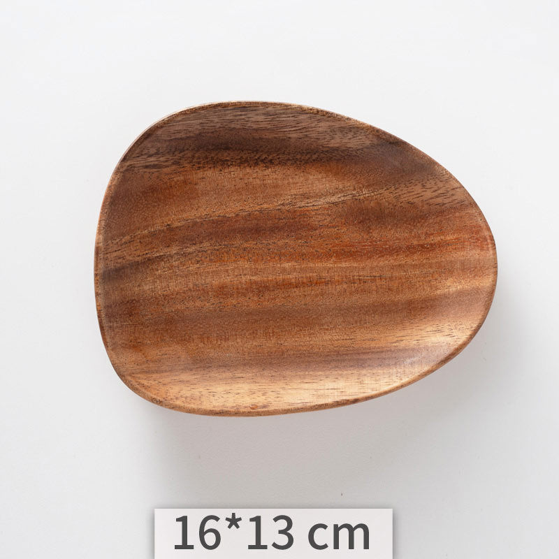 A set of acacia wooden trays with an irregular shape, displayed in various sizes on a white kitchen surface. Natural decor. Minimalist decor piece with warmth and harmony. 