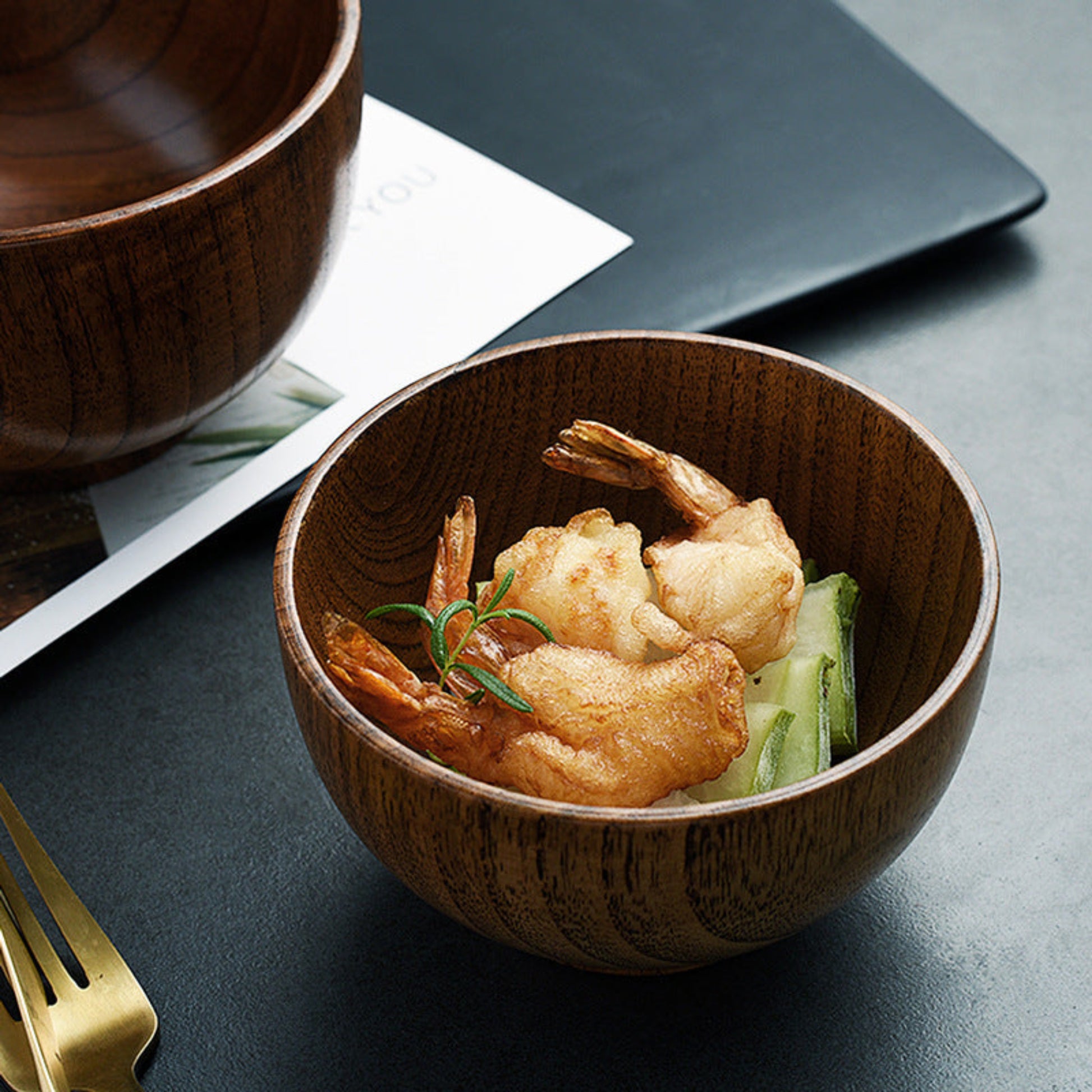Wooden bowl with fried prawns and vegetables on a dark surface. Solid wood. Japanese style. Earthy, warm and natural ambience. 