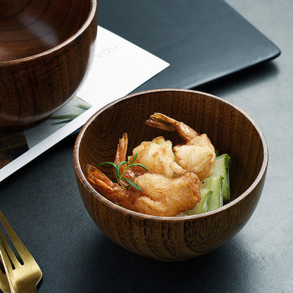 Wooden bowl with fried prawns and vegetables on a dark surface. Solid wood. Japanese style. Earthy, warm and natural ambience. 