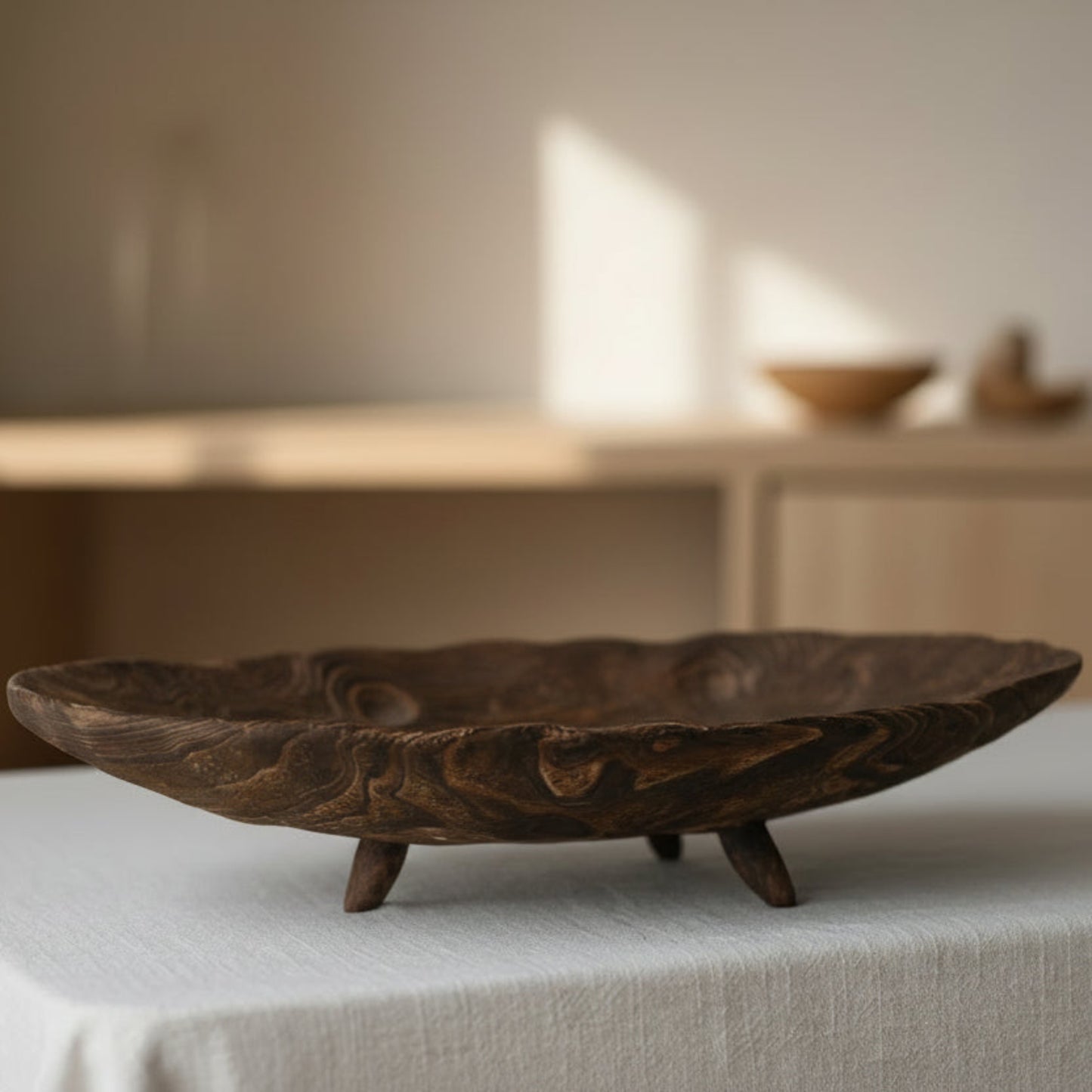 Large wooden tray with carvings on a light fabric surface with a blurred beige background. Minimalist and Scandinavian home decor with earthy ambience. 
