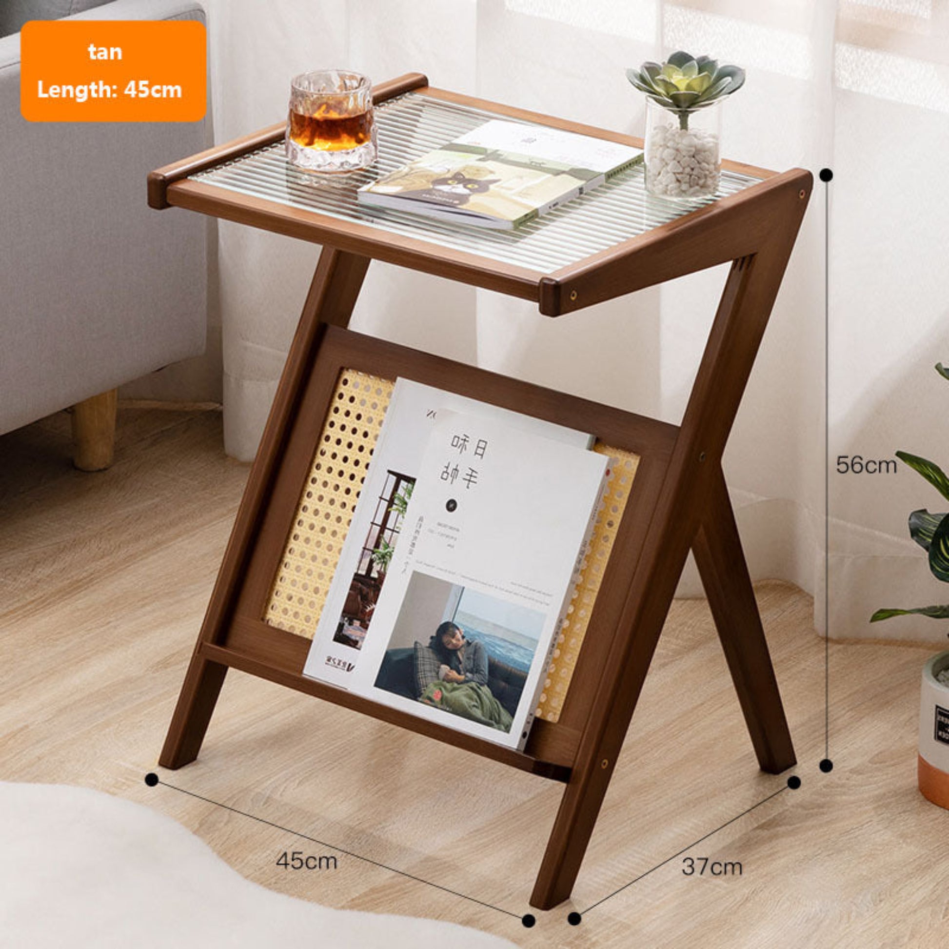 Wooden side table with glass top, books, and a glass of tea in a room setting. Minimalist Japanese bamboo furniture on a wooden floor and a white curtain in the background. Clean lines, natural materials, and timeless pieces that bring warmth and balance to every home. 