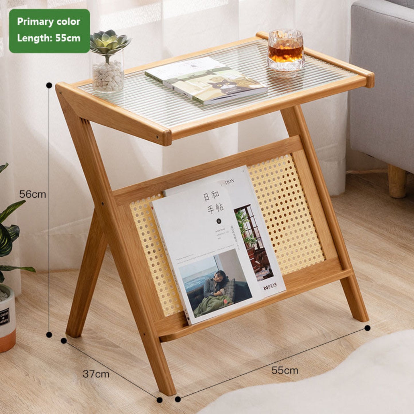 Wooden side table with glass top, books, and a glass of tea in a room setting on a wooden floor. Minimalist Japanese bamboo furniture on a wooden floor and a white curtain in the background. Clean lines, natural materials, and timeless pieces that bring warmth and balance to every home. With measurements. 