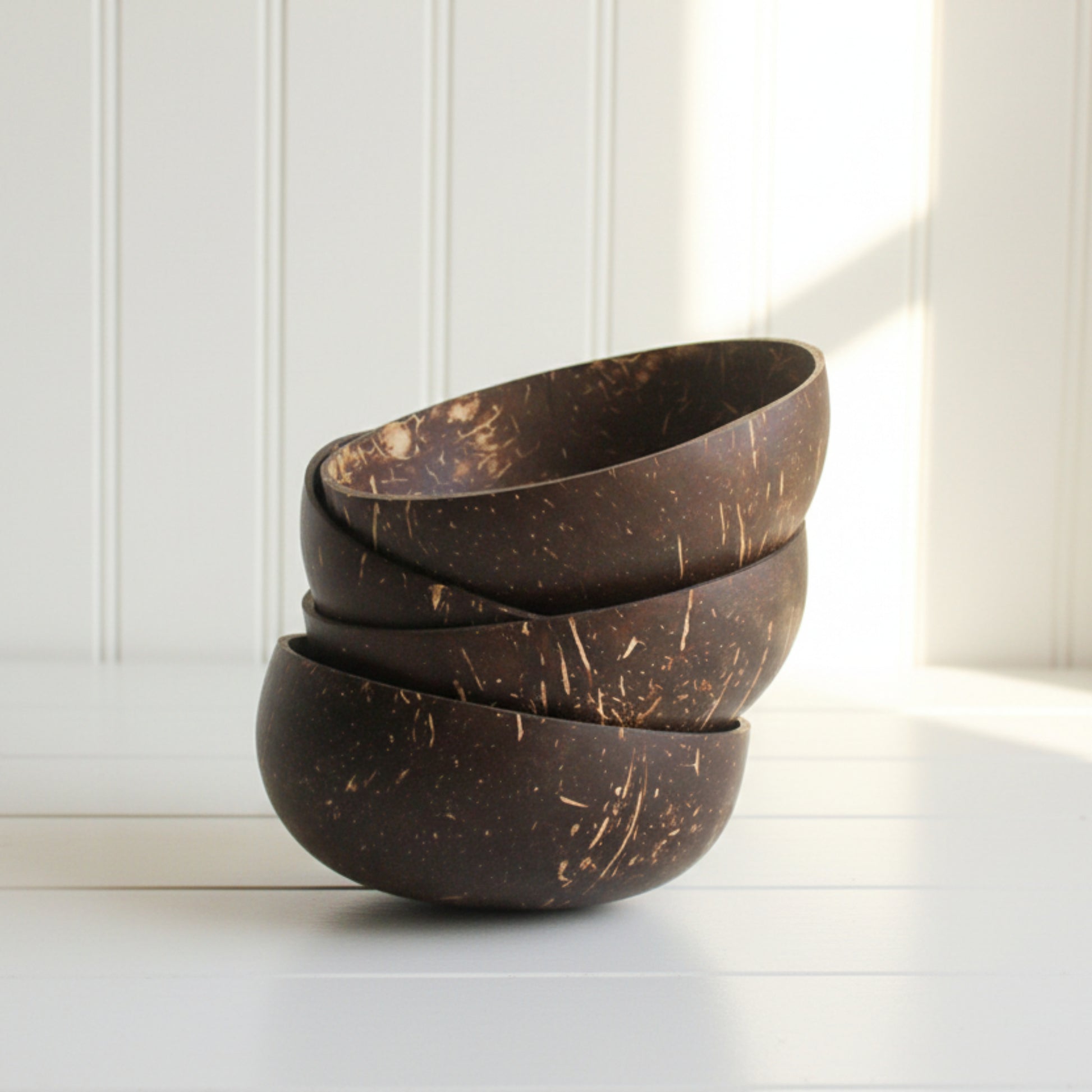 Set of three eco-friendly non-toxic coconut bowls on a white surface with a white background.