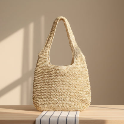 Woven beige handbag on a wooden surface with a neutral, warm, beige background. 