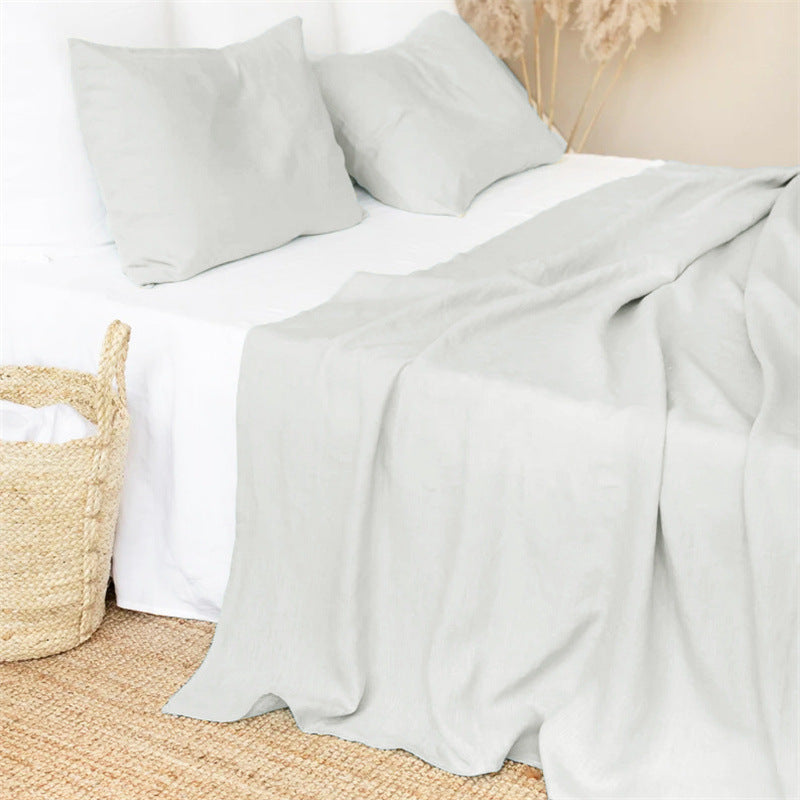 Bed with light plain linen bed sheet and pillows in a minimalistic earthy and warm room.Earthy and natural home and bed decoration and warm look and feel. 