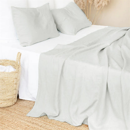 Bed with light plain linen bed sheet and pillows in a minimalistic earthy and warm room.Earthy and natural home and bed decoration and warm look and feel. 