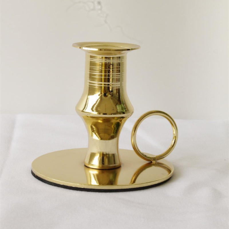Gold candle holder on a white background. French golden retro candle holder on a white background. Minimalistic home decor. 