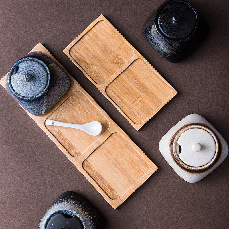 Four ceramic pots with two wooden bases on a dark brown background. Modern accessories, natural materials, and timeless kitchen piece. 