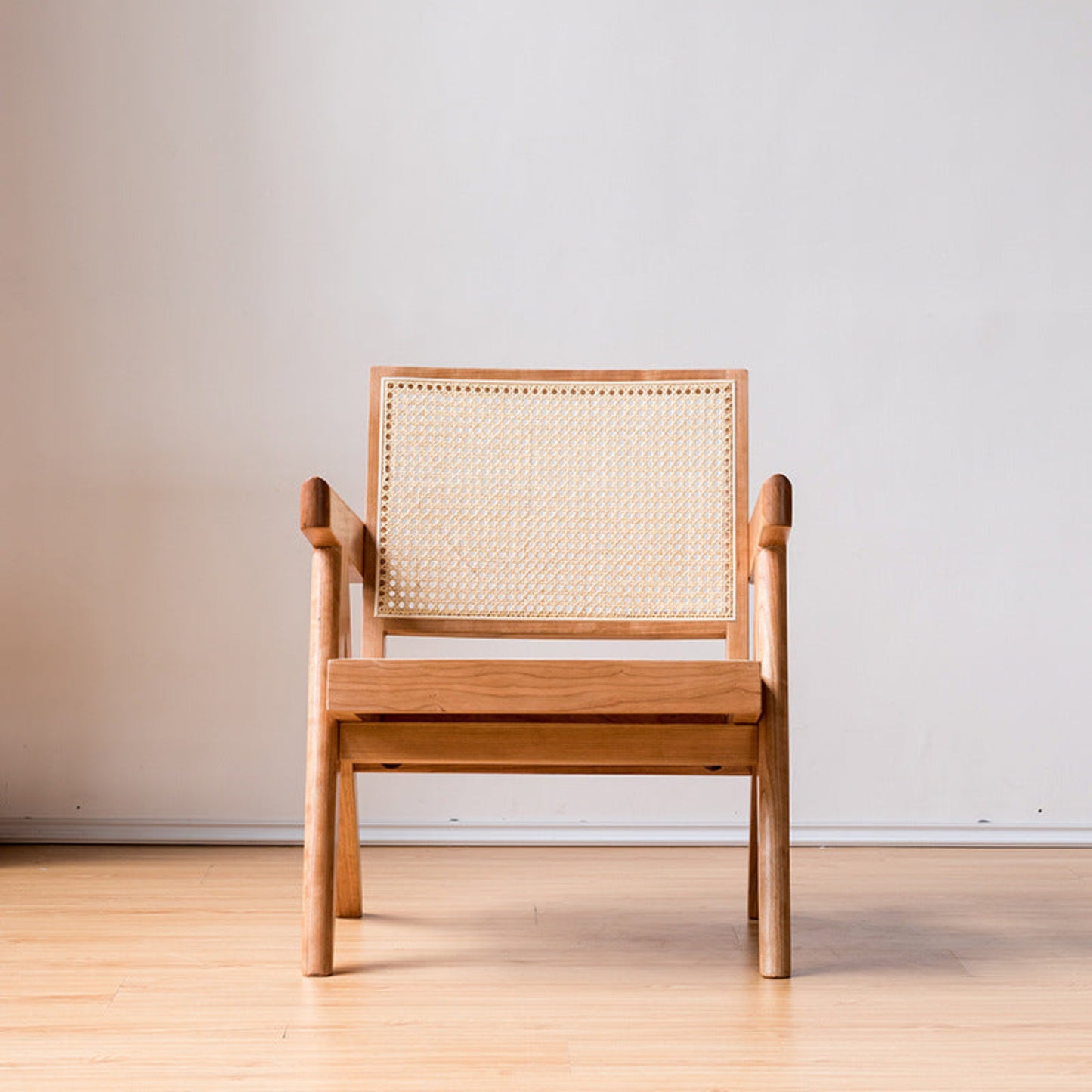 Wooden chair with woven backrest on a wooden floor. and a white wall background. Minimalist furniture design. Modern chair interior with clean lines, natural materials, and a timeless pieces that brings warmth and balance. Chair pictured from the front. 