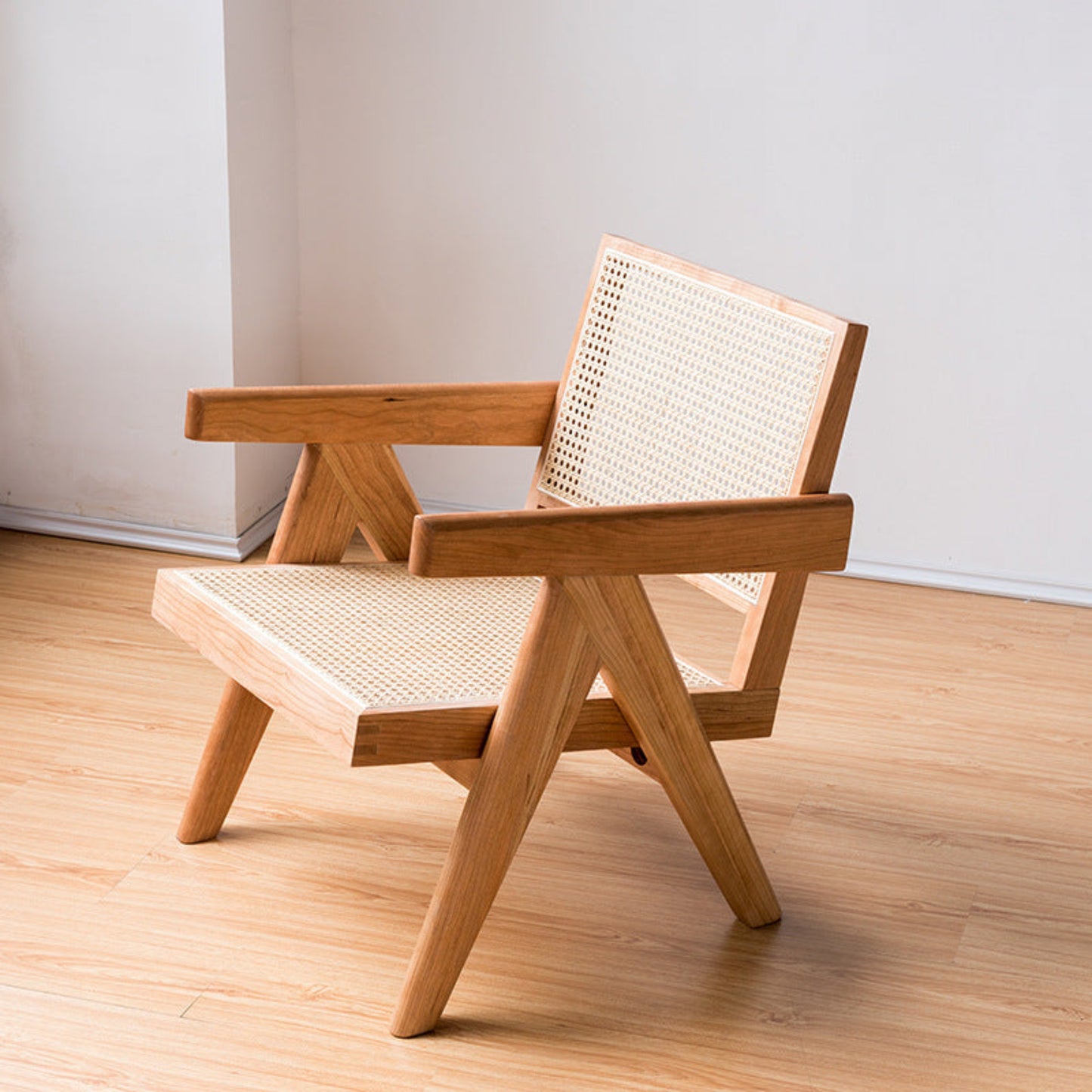 Wooden chair with woven backrest on a wooden floor and a white wall in the background. Minimalist furniture design. Modern chair interior with clean lines, natural materials, and a timeless pieces. Warm, earthy and balance.